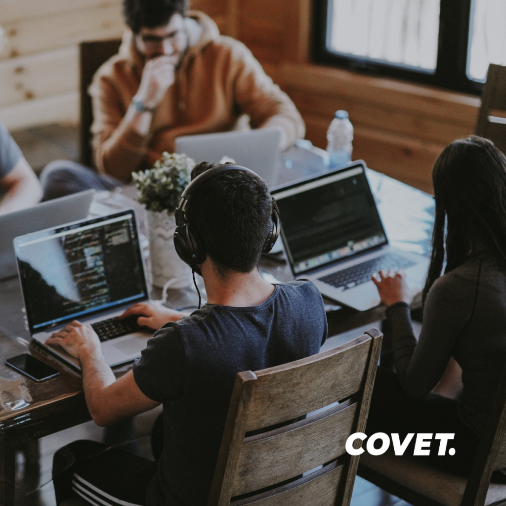 An image of a group of people at a desk working from their laptops. Over top of the image is the text “Things to consider before starting your new website”. In the bottom right corner is the logo for Covet Inc. The stock image used is from: https://unsplash.com/photos/QckxruozjRg